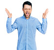 © Krakenimages.com - Hispanic man with beard wearing casual business shirt celebrating mad and crazy for success with arms raised and closed eyes screaming excited. winner concept
