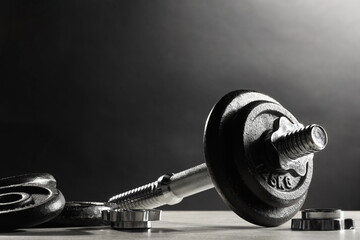 Wall Mural - Parts of barbell on light table against dark background