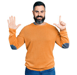 Wall Mural - Hispanic man with beard wearing casual winter sweater showing and pointing up with fingers number seven while smiling confident and happy.