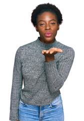 Canvas Print - Young african american girl wearing casual clothes looking at the camera blowing a kiss with hand on air being lovely and sexy. love expression.