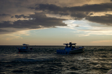 Wall Mural - sunset cruise views from the boat. other boats seen on the horizon as the sun is setting