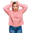 © Krakenimages.com - Hispanic woman with pink hair wearing casual winter sweater doing bunny ears gesture with hands palms looking cynical and skeptical. easter rabbit concept.