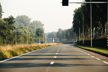 Empty highway in Haarlem, Netherlands on a warm summer day, viewed from the car window from a driver's perspective, showcasing a clear and tranquil road with scenic background plates