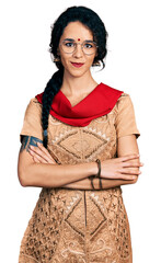 Young indian woman wearing traditional dress and glasses happy face smiling with crossed arms looking at the camera. positive person.