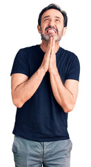 Sticker - Middle age handsome man wearing casual t-shirt begging and praying with hands together with hope expression on face very emotional and worried. begging.