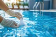 © Igor - Service worker pouring salt in swimming pool water House and Hotels Maintenance of clean and disinfection pools