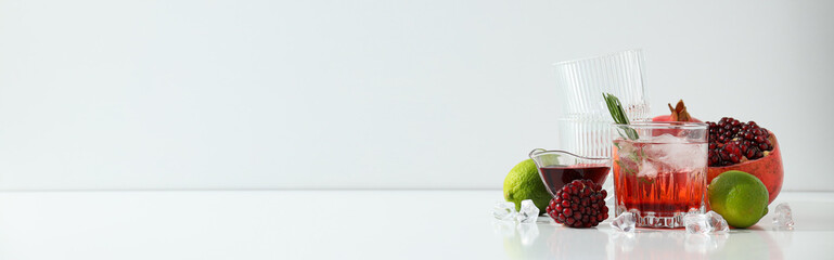 Wall Mural - Red cocktail with fresh pomegranate and lime on a white background