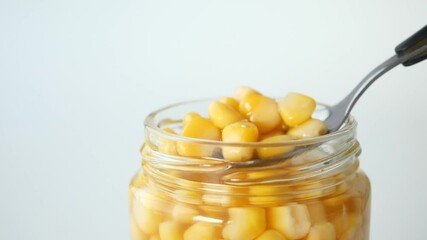 Canvas Print - spoon pick Sweet corns from a container 