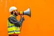 © BetterPhoto - A construction worker in a reflective vest and hard hat using a megaphone against an orange background, representing communication and safety.