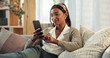 © peopleimages.com - Cellphone, indian woman and smile on sofa in home in living room, texting and communication on mobile. Lounge, couch and happy person for online dating app, notification and internet relationship