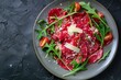 © LimeSky - Top view of beef carpaccio with parmesan and arugula on black plate
