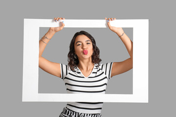 Sticker - Beautiful young woman with stylish accessories and frame blowing kiss on grey background