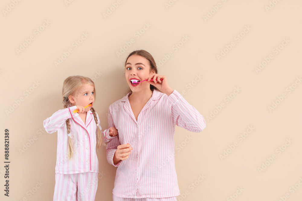Thoughtful mother and her little daughter brushing teeth on beige background