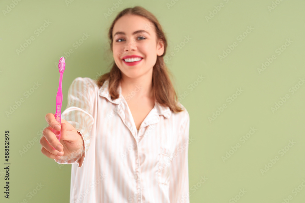 Beautiful young woman with toothbrush on green background