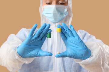 Canvas Print - Laboratory worker with test tubes on beige background