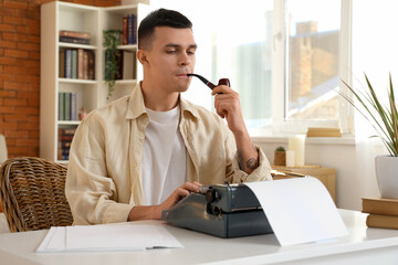 Poster - Young author with vintage typewriter smoking pipe at table in office