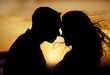 © SneakyPeakPoints/peopleimages.com - Sunset, silhouette or couple touching forehead for love, trust or kiss on honeymoon. Man, woman or shadow in nature with hug, passion or support in relationship on trip for milestone or celebration