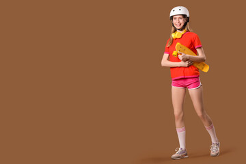 Poster - Beautiful young woman in helmet with skateboard on brown background