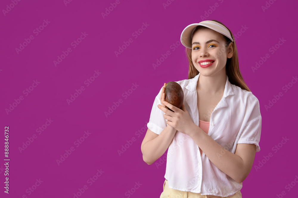 Beautiful young woman with sweet mango fruit on purple background