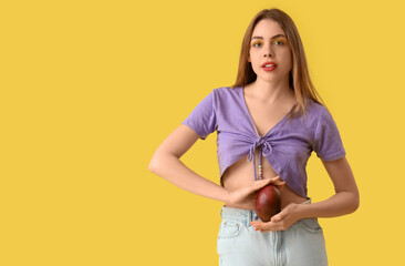 Poster - Beautiful young woman with sweet mango fruit on yellow background