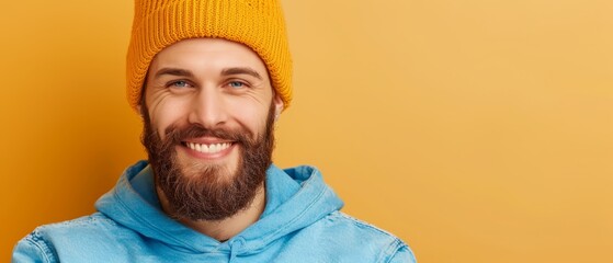 Wall Mural -  A bearded man, donning a yellow knit hat and a blue hoodie, smiles at the camera