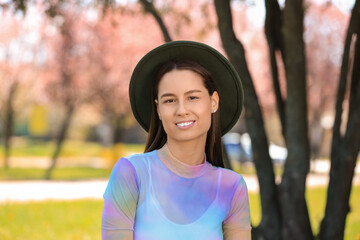 Wall Mural - Beautiful young woman in park on sunny spring day