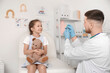 © Pixel-Shot - Male pediatrician vaccinating little girl with toy on couch in clinic