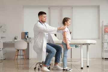 Sticker - Male pediatrician examining little girl in clinic