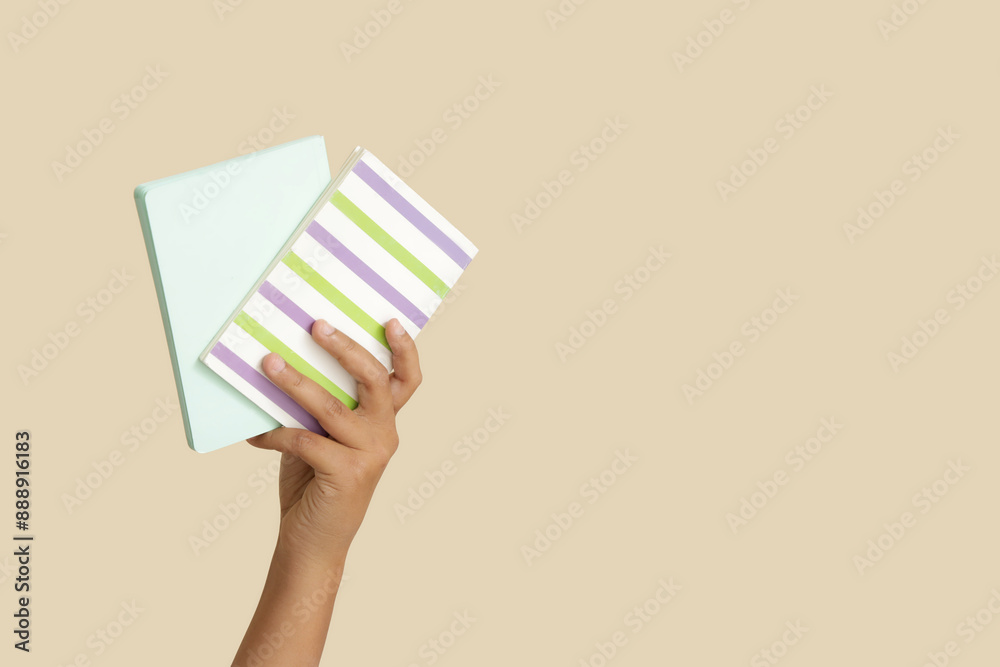 Child with notebooks on beige background