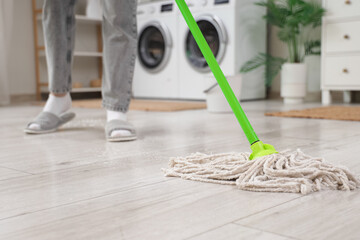 Poster - Woman mopping floor in laundry room, closeup