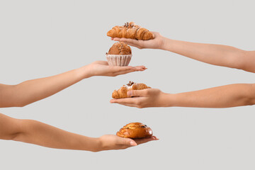 Wall Mural - Female hands with different tasty pastry on grey background