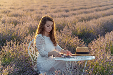 Canvas Print - A woman sits at a table in a field of lavender