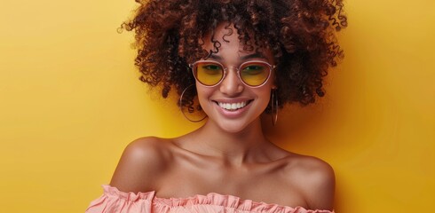 Canvas Print - Smiling Woman With Curly Hair Wearing Pink Sunglasses Against Yellow Background