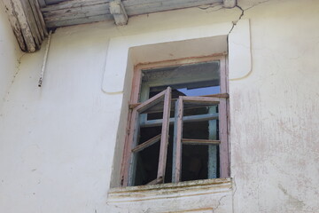 Aufkleber - A picture of a window with a wooden frame on the side of a white building.