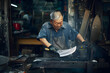 © john - An East Asian Ironworker manufactures a Chinese kitchen knife.