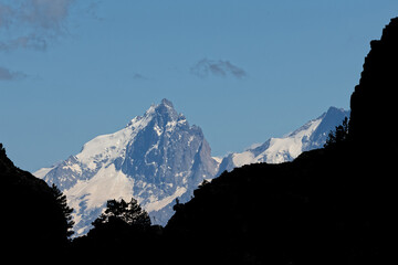 Canvas Print - Snowy summits of La Meije mountain range over dark forefront slopes