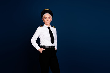 Canvas Print - Photo of lovely pensioner lady professional commercial pilot confident pose dressed aviator uniform isolated on dark blue color background