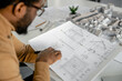 © zinkevych - Expert man architect drawing blueprints in his workplace