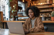 © lermont51 - Young woman working remotely in cafe