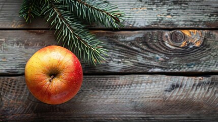 Canvas Print - Top view of a fresh red yellow apple on a wooden surface with a green pine branch nearby promoting healthy eating during winter celebrations