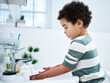 © Courtney/peopleimages.com - Boy, child and washing hands in bathroom, home and profile with dirt, pain or stains for hygiene. Toddler, learning and cleaning routine with water, faucet and development at family house in Bogota