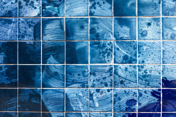 Tiles on the wall of a building with an abstract blue pattern