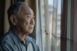 © Bijac - thoughtful elderly asian man gazing out nursing home window soft natural light muted colors conveying melancholy and reflection