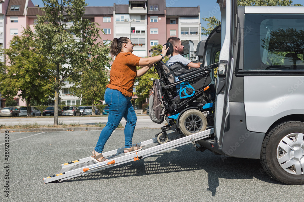 Order Man Ramp Assistant Female assistant helping a man with disability to enter an accessible ...