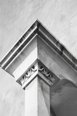 Poster - A black and white photo of a city building corner with stone walls, architectural details, and urban atmosphere