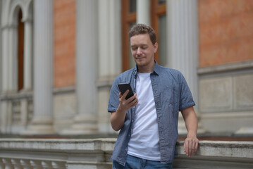A man on the street using a smartphone. Concept of communication in social networks and messengers.