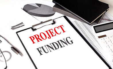 Poster - PROJECT FUNDING text on clipboard on chart with notebook and calculator