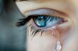 © Ben - A close-up of a blue eye with a tear falling, capturing the raw emotion and vulnerability of human sorrow and grief