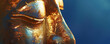 © Volodymyr - A close-up of a golden Buddha face, highlighting the calm expression and fine craftsmanship, set against a deep blue background.