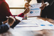 © Wasan - Business consulting meeting is discussing business plan analysis with financial data and business growth charts to plan strategies for generating company profits.